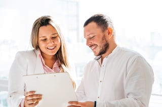 colleagues-discussing-project-looking-clipboard