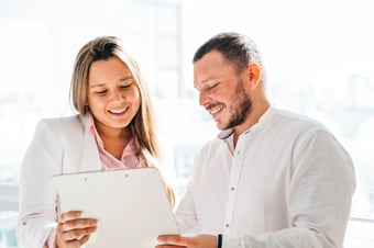 colleagues-discussing-project-looking-clipboard
